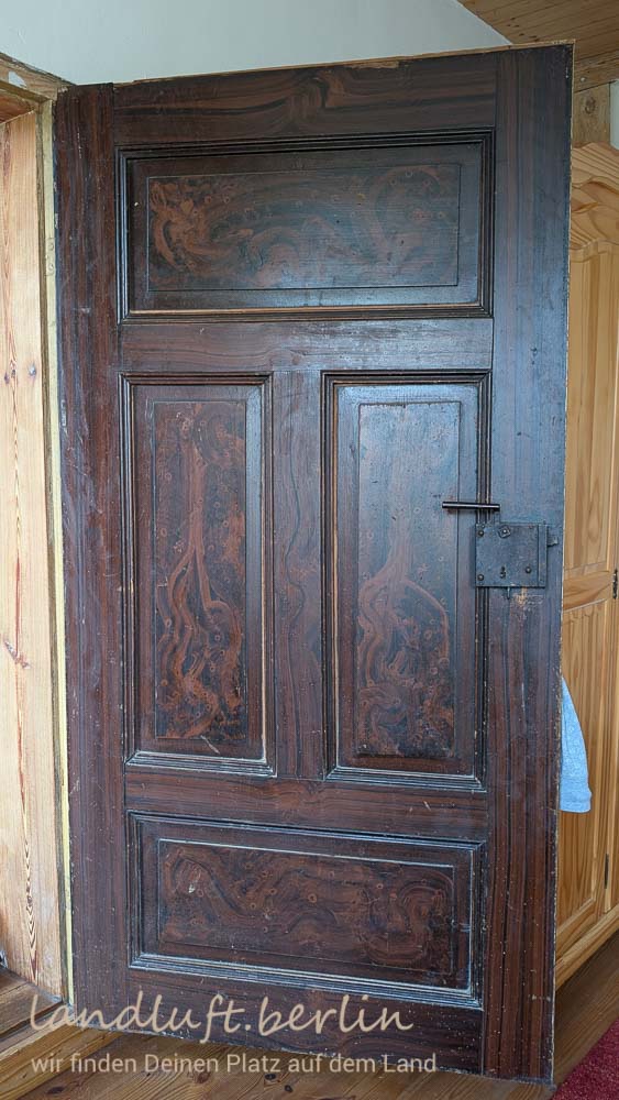 Alte Tür mit aufgemaltem Wurzelholzmuster