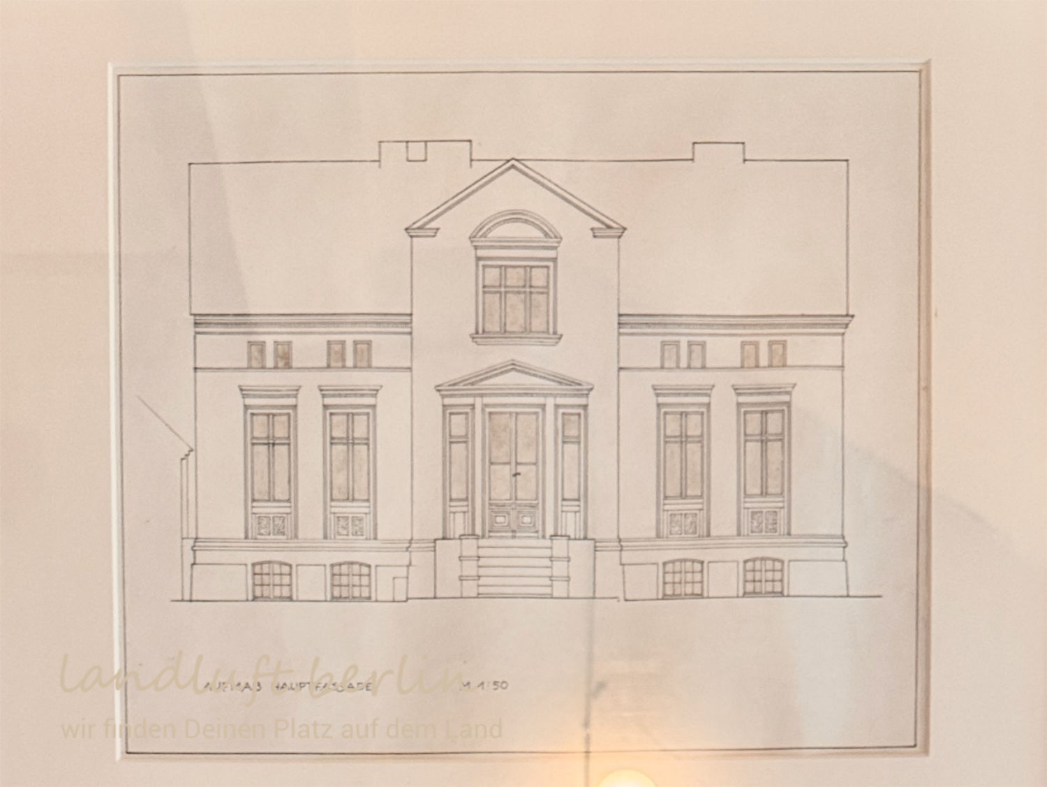 Ansicht der Wohnhaus-Fassade, hängt gerahmt im Wohnhaus