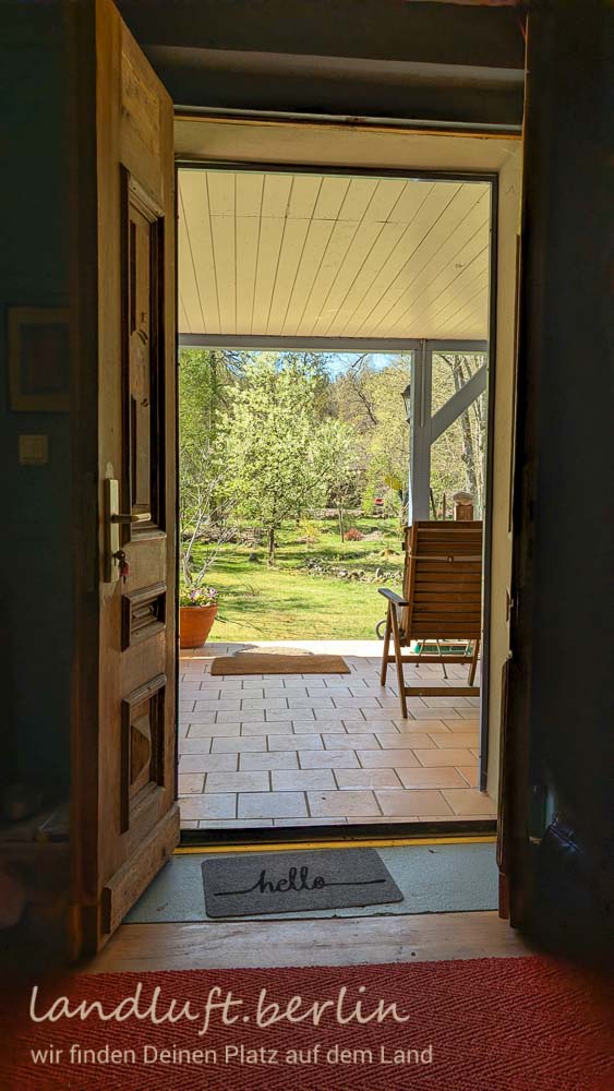 Blick durch die Eingangstür über die Terrasse in den Garten