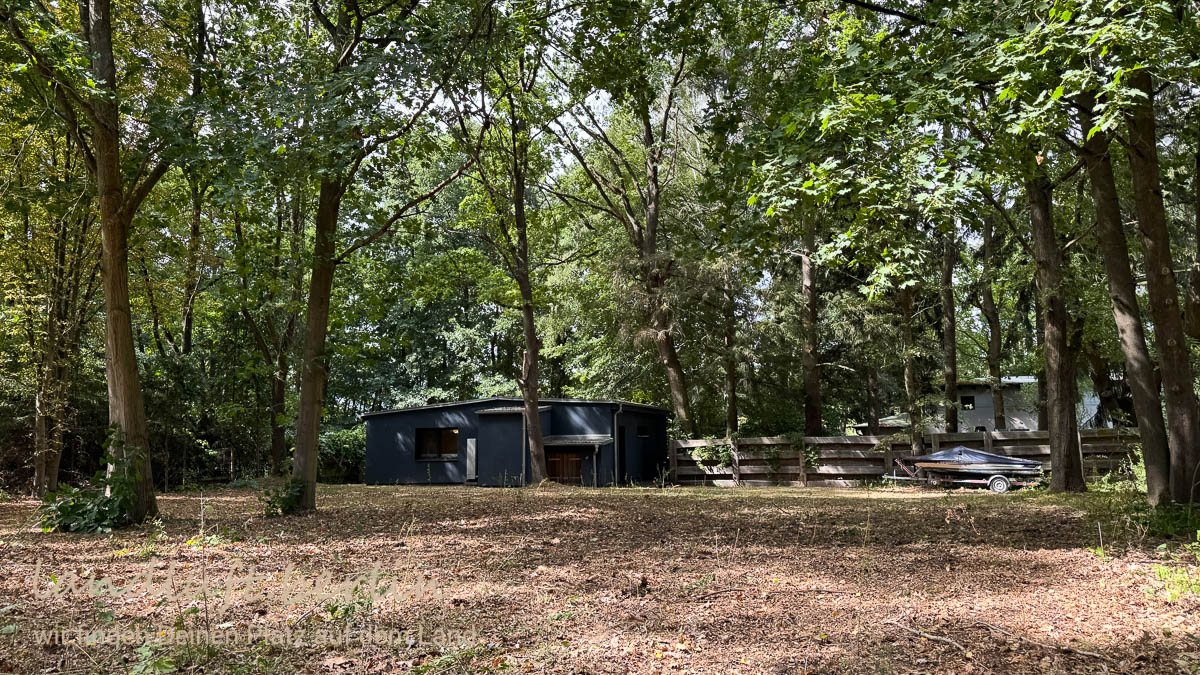 Die mit Bäumen bestandene große Wiese hinter der Haus