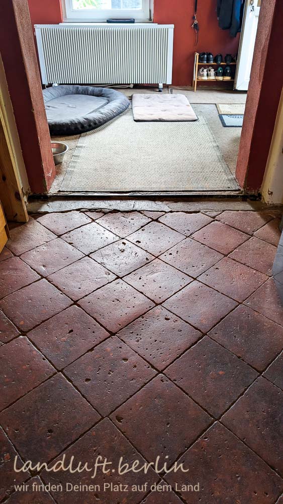 Die schön abgenutzten Terrakottafließen im Flur. Blick in den großen Windfang