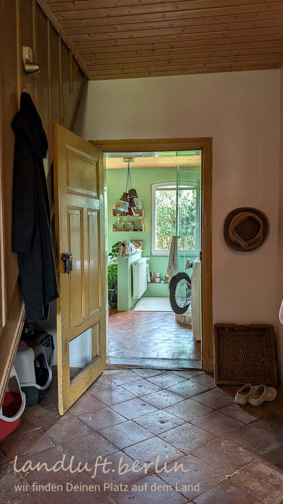 Flur mit schönen abgelaufenen Terrakottafliesen, Tür zum Bad