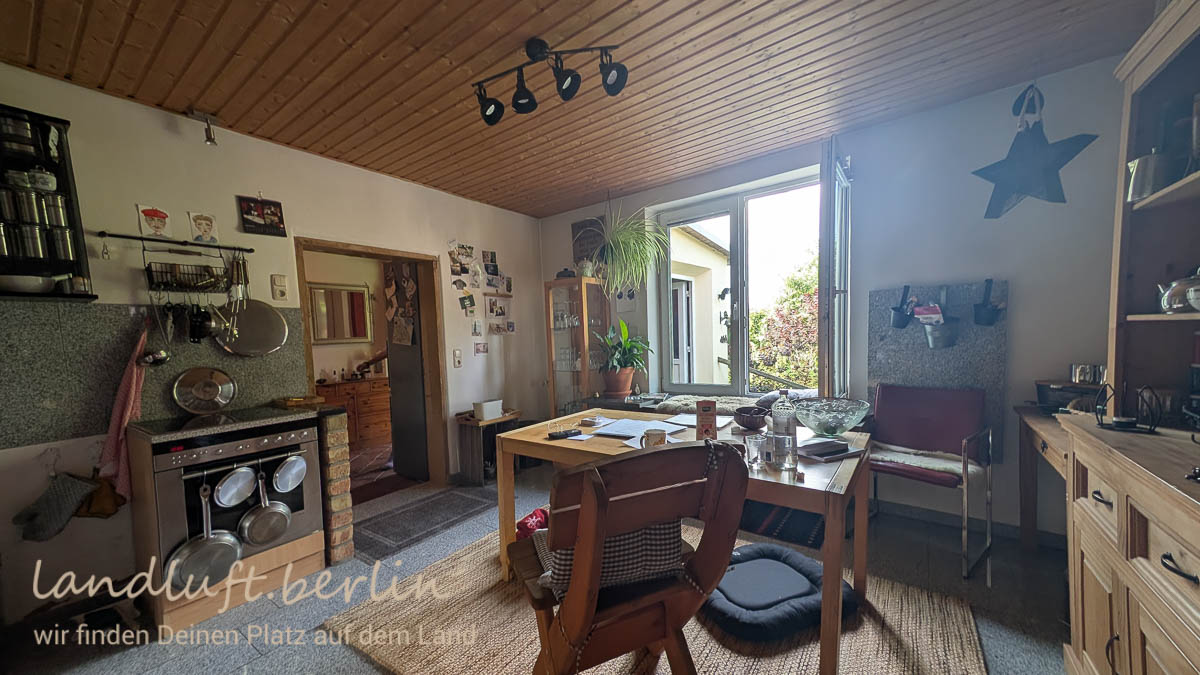 Küche, durch die Tür der Flur, durch das Fenster blickt man auf die Eingangstür im Windfang