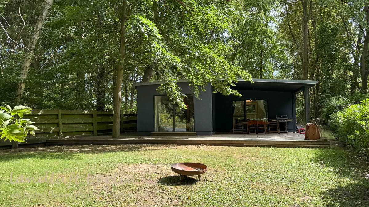 Seeseite des Hauses mit Wohnzimmer und Schlafzimmer, von welchen man jeweil direkt auf die teilweise überdachte Terrasse treten kann.